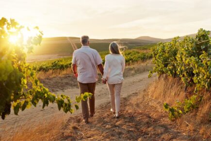 Older couple walking through a field.