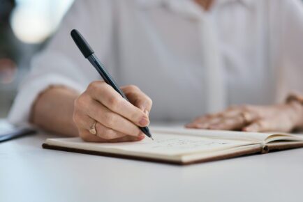 Closeup shot of an unrecognisable businesswoman writing notes in an office