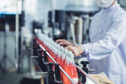 Drink factory – closeup hygiene worker working check juice glass bottled in production line